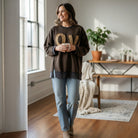 Model wearing LOVE UNTAMED TOP - Easel in dark wash with leopard patch letters, stylish and comfy for any occasion.