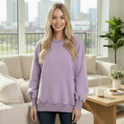 Model wearing the SOFT HORIZONS CREWNECK in lavender, showcasing its soft fleece and high-low design.