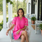 Model wearing the Kersten Ric Rac Dress, Hot Pink, showcasing ruffle sleeves on a porch.