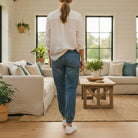 Woman wearing YARA JOGGERS by Risen Denim, showcasing a relaxed fit and stylish look in a cozy living room.