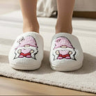 HUGS & HEARTS SLIPPERS featuring a cozy embroidered character in a pink hat and heart details for added charm.