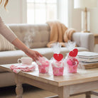 Too Cute to Eat Valentine Sock Cupcakes wrapped in cellophane with heart tags on a coffee table