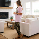 LULU MAC MOSSY OAK - COMFORT COLORS TEE (pink) worn with camo leggings in a cozy living room setting.