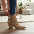 ARISA STRAPPY ANKLE BOOTS shown on a model, featuring buckled straps and a stylish pointed toe.