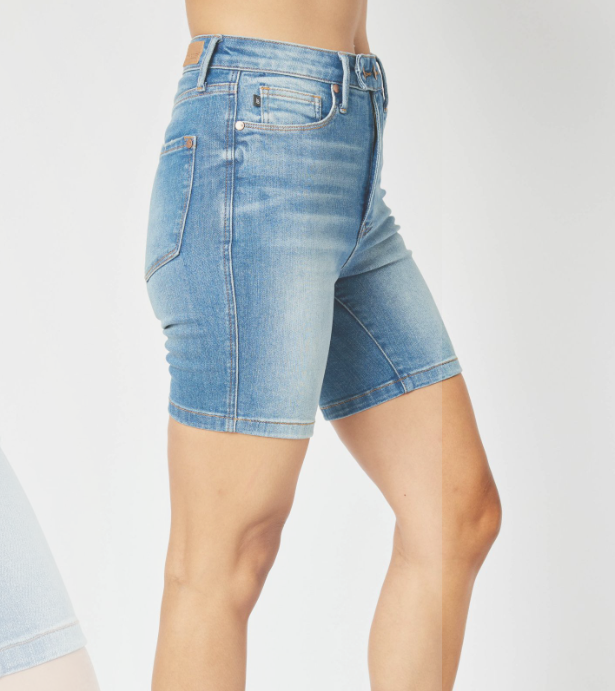 Side view of Judy Blue Lola Tummy Control Shorts in medium wash, high-waisted denim with double buttons.