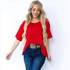 Model in a red ribbed oversized top styled with jeans, showcasing a casual and chic everyday look.