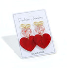 CHERISHED HEARTS EARRING featuring red acrylic heart drops and gold-tone bow stud on a display card.