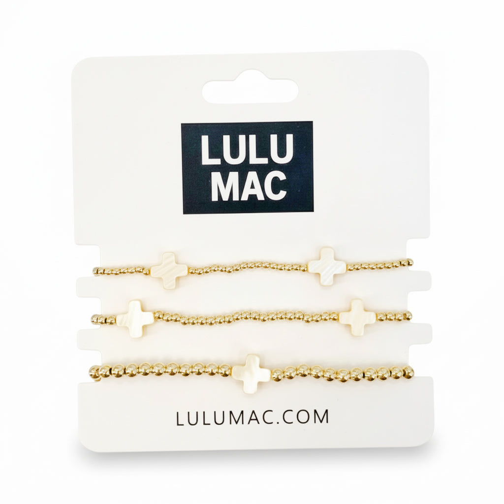 LULU MAC - GOLDEN GRACE BRACELET SET featuring three gold-tone bracelets with cross details.