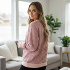 Woman wearing LAZY DAY LEOPARD CREWNECK pink leopard print sweatshirt at home.